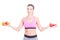 Woman at gym holding fruits and weights as balance