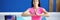 Woman in gym sits in lotus position in front of camera