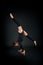 Woman gymnast showing athletic skill against dark background
