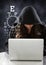 Woman hacker using a laptop in front of dark background