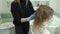 Woman hairdresser colorist at home in the bathroom puts paint on the hair of a young woman, applies paint with a brush