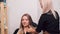 Woman hairdresser combing long blonde hair. The girl came to the beauty salon.