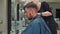 Woman hairdresser demonstrating expertise with clippers on a man\'s hair in salon
