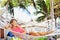 Woman in the hammock under the palms on the tropical beach