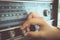 Woman hand adjusting the button vintage radio receiver