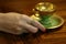 Woman hand with an antique emerald ring and mocca cup