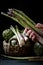 Woman hand with asparagus on textured background with artichokes in a basket 3