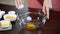 Woman hand breaks chicken egg in bowl. Chicken egg falls into glass bowl.