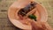 Woman hand breaks off piece of chocolate cake with teaspoon. Young lady eating