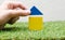 Woman hand building a small house with colorful wooden blocks