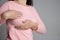 Woman hand checking lumps on her breast for signs of breast cancer on gray background. Healthcare concept