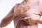 Woman hand checking lumps on her breast for signs of breast cancer on gray background. Healthcare concept