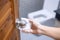 Woman hand cleaning toilet doorknob by wet wipe tissue, protection coronavirus or Corona Virus Disease Covid-19 at home. Clean
