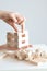 Woman hand constructing a tower of wooden blocks on a white background