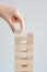 Woman hand constructing a tower of wooden blocks on a white background