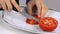 Woman Hand is cutting Tomato