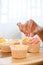 Woman hand decorating cupcake, making cupcake in her free time in kitchen