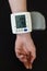 Woman hand with electric tonometer measuring blood pressure