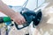 Woman hand filling gasoline car in petrol station