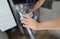 Woman hand fills drum of washing machine closeup