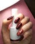 Woman hand finger black and red flower manicure gel nail polish swatch design white bottle beauty fashion photo