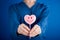 Woman hand giving pink heart shaped lollipop with smile