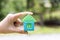 Woman hand hold home block with blur green background Concept for dream home, family fulfillment