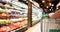 Woman hand hold supermarket shopping cart with Abstract grocery store blurred defocused background