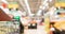 Woman hand hold supermarket shopping cart with grocery store blurred background