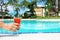 Woman hand holding an appetizing orange cocktail at poolside