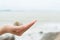 Woman hand holding beach shell in a tropical place.