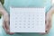 Woman hand holding calendar for planner, business, check for period schedule, healthy and travel plan concept