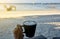 Woman hand holding cappuccino cup at the beach.