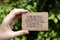 Woman hand holding cardboard card with words Live Laugh Love