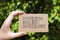 Woman hand holding cardboard card with words Reduce Reuse Recycl