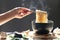 Woman hand holding chopsticks of instant noodles in cup with smoke rising and garlic on dark background, Sodium diet high risk