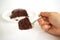 Woman hand holding fork served chocolate cake with chocolate fud
