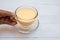 Woman hand holding a glass cup of indian spiced masala tea on white wooden table