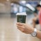 Woman hand holding green coffee paper cup, drinking hot coffee in the city indoor. business and lifestyle concept