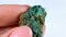 Woman hand holding green crystal Jasper on light background close up