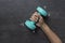 Woman hand holding green dumbbell