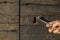 Woman hand holding a key with vintage keyhole on wooden door