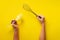 Woman hand holding kitchen utensils on yellow background. Baking tools - brush, whisk, spatula. Bakery, cooking, healthy homemade