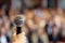 Woman hand holding microphone at business conference on blurry background journalist with mic