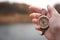 Woman hand holding a old compass with broken glass. Travel concept, path selection, navigation, tourism, hiking. Autumn background