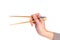 Woman hand holding pair of wooden chopsticks