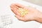 Woman hand holding pills and empty blisters of medicines on background