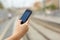 Woman hand holding a smart phone in a train station