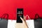 Woman hand holding smartphone with shopping bag, China 11.11 single day sale concept