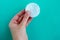 Woman hand holds cotton sponge on blue background